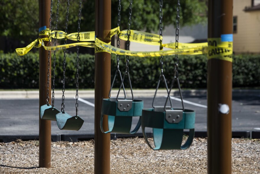 Caution tape surrounds playground equipment at McKinney Heights Park in South Austin. Park amenities in Austin were closed on March 28 to slow the spread of COVID-19.