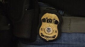  a closeup of a badge that reads "ice u.s. officer" 
