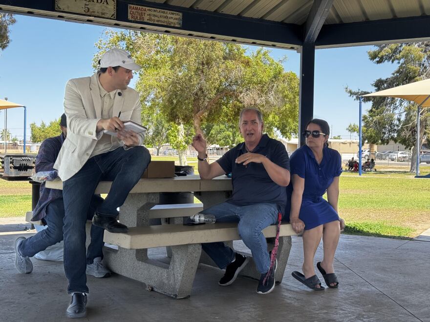 Carlos Adams meets with Yuma residents under Kennedy Park ramada.