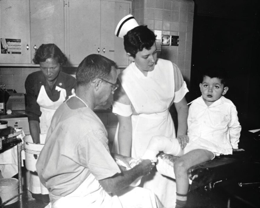 Doctors and nurses treat a child with polio.
