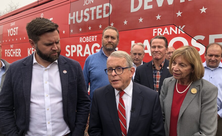 Gov. Mike DeWine (R-Ohio), incumbent running for re-election, speaks to reporters while joined by J.D. Vance, Republican candidate for U.S. Senate, and other Republican candidates for statewide office outside their tour bus.