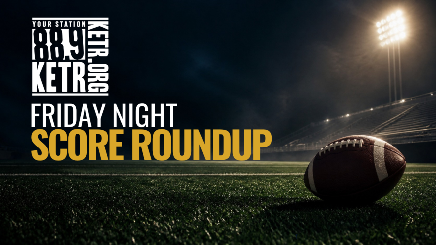 Friday Night Score Roundup image with a football in the foreground lying on a nighttime lit gridiron, stands empty.