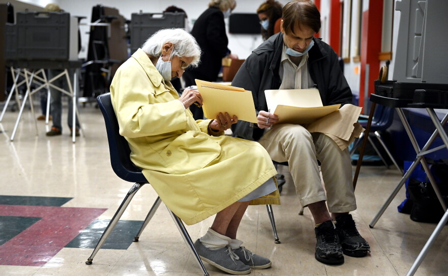 Ann Dawson, 97, and her 63-year-old son, James M. Dawson, fill out their ballots at Slade Middle School on Nov. 2, 2021, in New Britain, Connecticut. Ann said, “It’s a good idea to vote.” James said, “I’m glad I got my mother to come out. I hope the two parties can come together.”