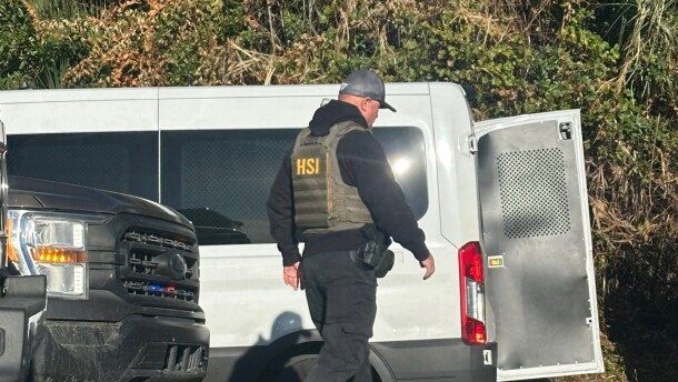 An agent from the U.S. Homeland Security, a federal law enforcement agency within the U.S. Department of Homeland Security, in Immokalee Wednesday morning. Workers on a tomato grower's bus were reportedly taken off the vehicle. An immigration support group, Unidos Immokalee, said several workers were in need of medical attention after they were removed from the bus.