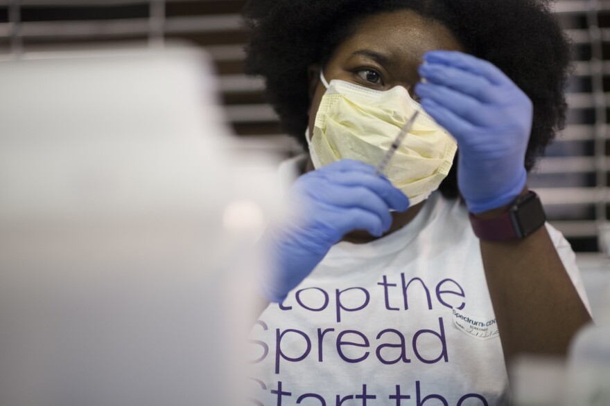 A volunteer draws a syringe of the COVID-19 vaccine at a Novant Health clinic at the Spectrum Center on Feb. 13, 2021.