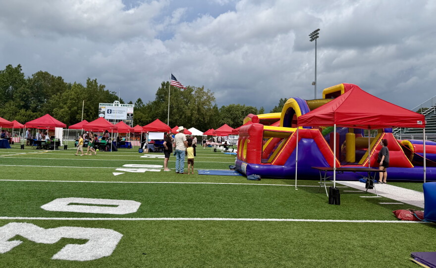 Families walk through the quiet carnival at the Nordonia High School football stadium. 