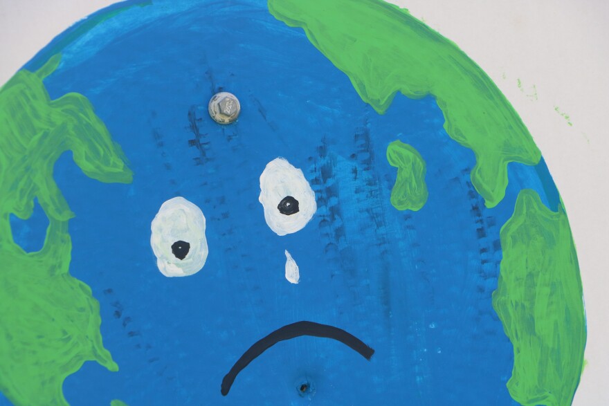 Crude drawing of the earth with eyes and a frown. It sheds a single tear.