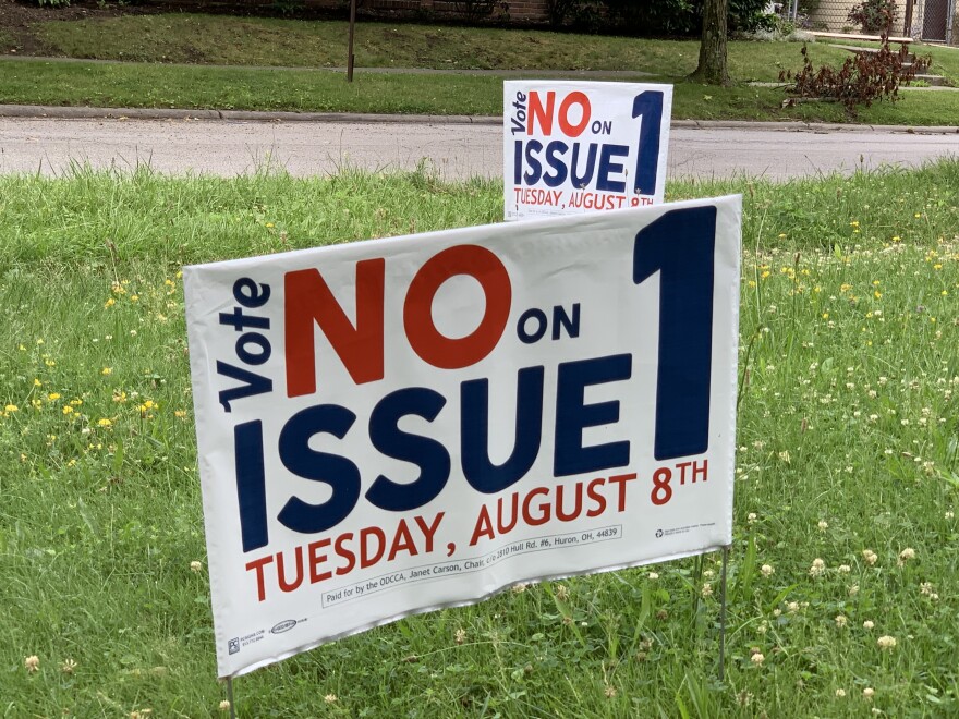 Two signs on a lawn read, "Vote no on Issue 1, Tuesday, August 8th"