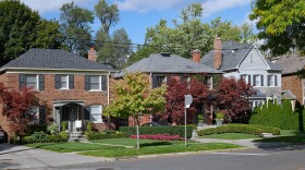 Suburban street with older brick detached houses.