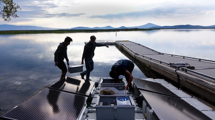 Mohammed Bawazeer (left) and Ian Riley carry a battery that will power the aeration system on Upper Klamath Lake for 32 hours, even if the sun isn't shining.