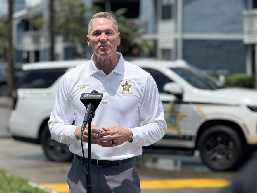 Hillsborough Sheriff Chad Chronister stands before a police car, ready to give a press conference.