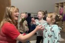 A woman in with long blond hair and a red shirt blows bubbles with three toddlers at a day care center in Stilwell, Oklahoma.