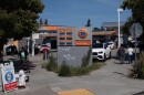 A 76 gas station in Oakland. The price displayed has been graffitied with an expletive, and an arrow that points to a $7 price for premium.