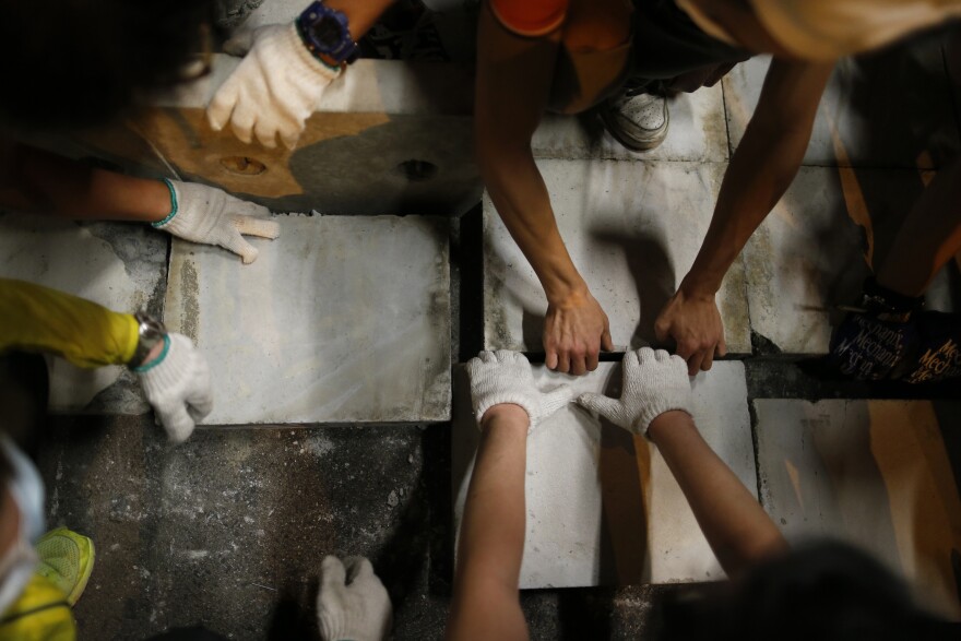 Pro-democracy protesters lay bricks inside a vehicle tunnel to block traffic leading to the financial Central district near the government headquarters in Hong Kong early Wednesday.