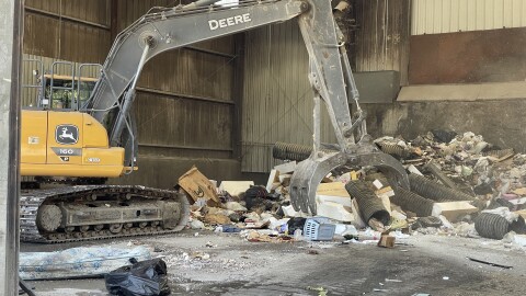 An excavator in the transfer station moves trash headed for a landfill in Rochester.