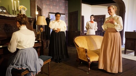 The women gather around Mrs. Daldry at the piano