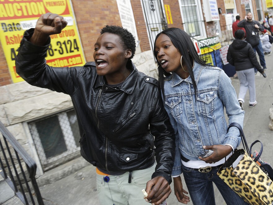 Charvae Day and Renay Battle react after the city's top prosecutor, Marilyn Mosby, announced criminal charges against all six officers suspended after Freddie Gray suffered a fatal spinal injury while in police custody.