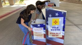Los Alamos County Elections Manager Victoria Martinez, right, and student clerk Katelyn Alarid retrieve absentee ballots from a drop box outside a public library in Los Alamos, N.M., on Thursday, May 12, 2022. 