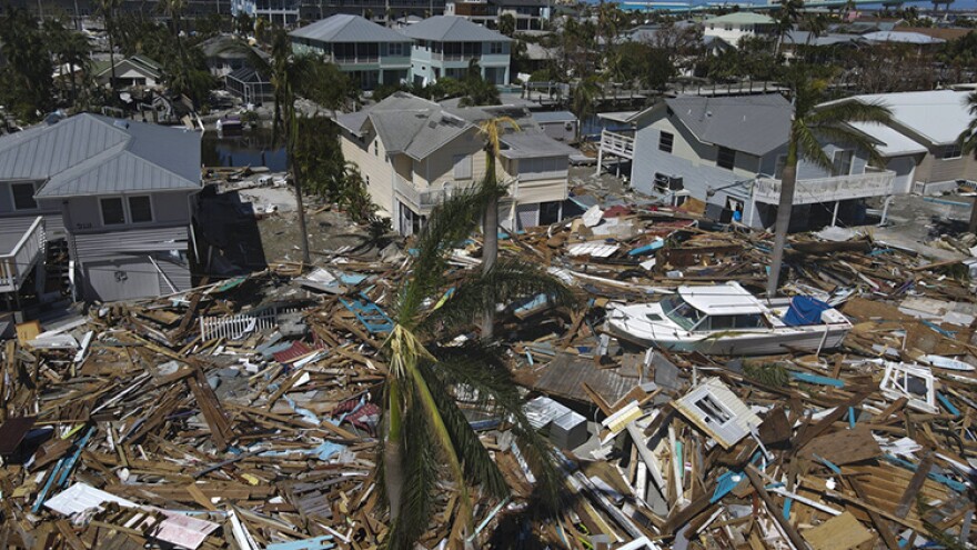 In this photo taken with a drone, debris from destroyed buildings swept from the beachfront lies amid damaged homes, two days after the passage of Hurricane Ian, in Fort Myers Beach, Fla., Friday, Sept. 30, 2022.