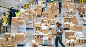 Workers sort packages by zip code during a media tour of the Amazon AGS5 facility on October 27, 2022 in Appling, Georgia. Amazon, the leading United States retail e-commerce company is preparing for the busy winter holiday season and plans to hire hire 150,000 full-time, seasonal and part-time workers to fulfill orders. (Photo by Sean Rayford/Getty Images)