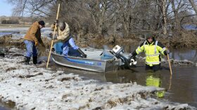 Tom Wilke, his son Chad, and Nick Kenny launch a boat into the swollen waters of the Elkhorn River to check on Wilke's flooded property, in Norfolk, Neb., on Friday, March 15. Nati Harnik/AP