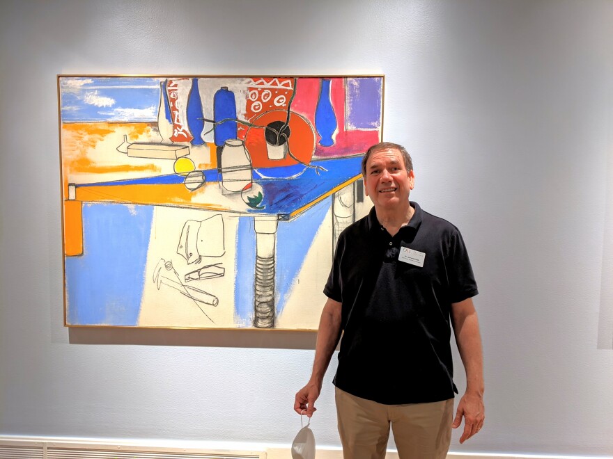 Jerry Smith, Chief Curator at the Dayton Art Institute, stands in from of a still life by Anne Tabachnick, who was both a renown artist and an instructor at DAI in the 1960s.