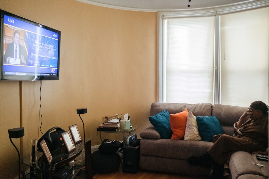 Raymonde Elian watches the daily coronavirus briefing from New York Gov. Andrew Cuomo on her day off from work in April. Despite the stress of work, she wanted to make sure she was getting the latest updates for perspective on what she was seeing at the hospital.