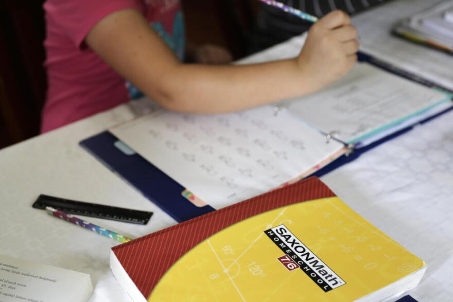 A homeschool math textbook rests on the table where Mabry Grant, 8, works on a lesson with her mom, Donya Grant, at their home in Monroe, Washington. (Ted S. Warren/AP)