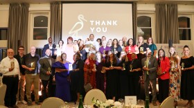 A group of award winners gather in a ball room