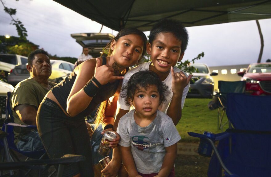 Wai'anae residents Jayda-Marie Tili, Jaylo Paris and Kayson Tili stand with their families as they were evacuated to a Walmart parking lot in Kapolei on Tuesday, July 29, 2025, in preparation for the tsunami threat. (AP photo/Michelle Bir)