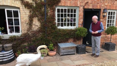 Composer John Rutter and one of his friendly neighborhood geese have a chat