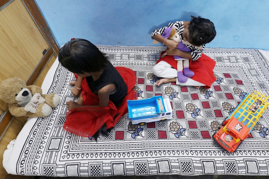 Twin sisters Tripti and Pari, who lost both their parents to COVID-19, play at a relative's home in Bhopal, India on May 11, 2021. A new study estimates that 8 million kids lost a parent or primary caregiver to a pandemic-related cause.