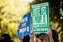 Supporters of the City of Austin’s Proposition Q hold signs during a press conference on Tuesday, Sept. 30, 2025, at Parque Zaragoza in East Austin. Michael Minasi / KUT News