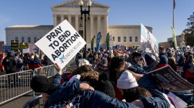 A group of anti-abortion protesters pray in front of the U.S. Supreme Court on Wednesday, Dec. 1, 2021, as the court hears arguments in a case from Mississippi, where a 2018 law would ban abortions after 15 weeks of pregnancy.