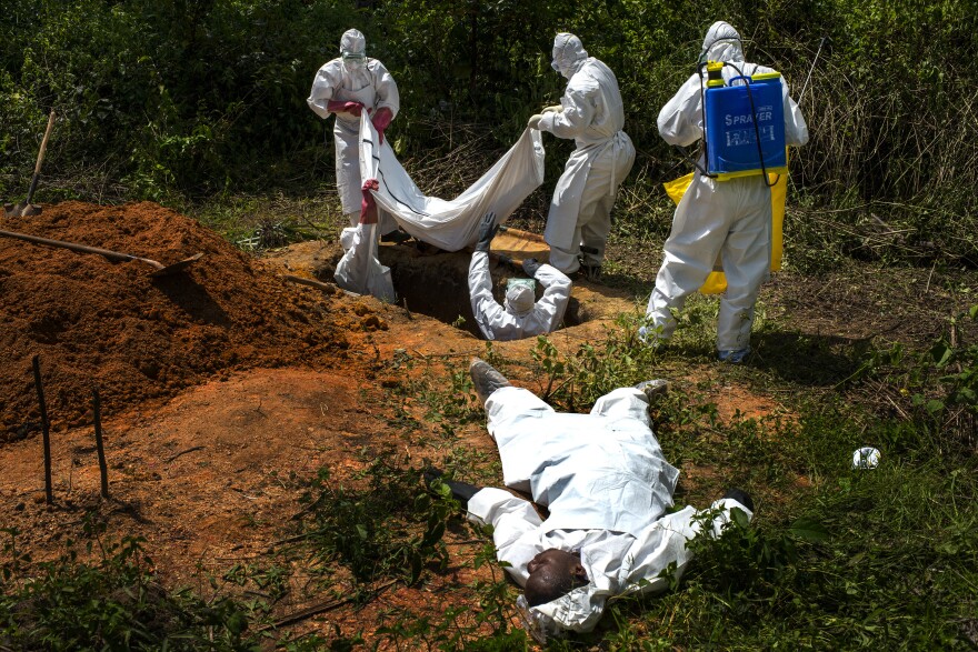 Alexander Morris lies flat on his back after he fainted due to the extreme heat inside a protective suit, while the Lofa County Health Department team buries his sister, on Nov. 7 in Voinjama, Liberia.