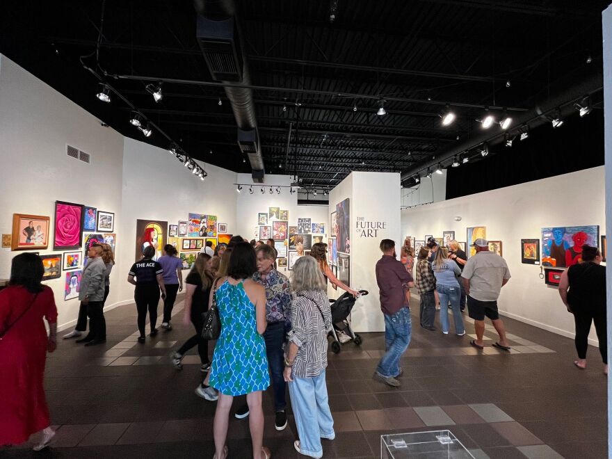 Guests view art in main gallery during 'Future of Art' exhibition.