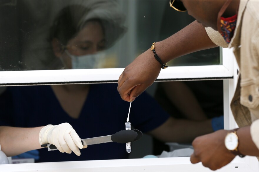 Person submitting swab at coronavirus testing facility.