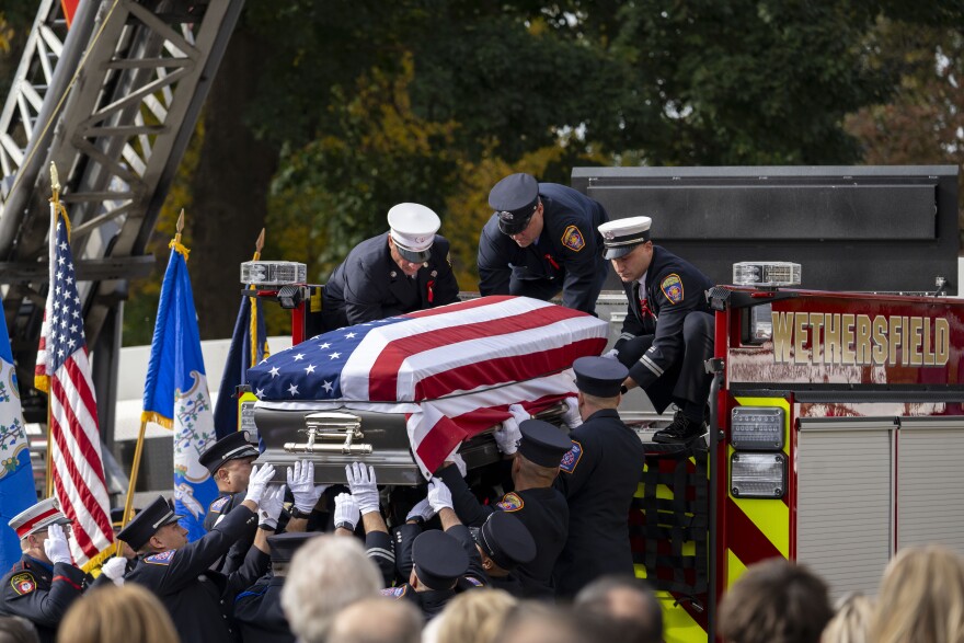 The casket of Wethersfield firefighter Robert Sharkevich, Sr. is lifted from engine 31 and carried into the Cathedral of St. Joseph in Hartford on October 28, 2024. He died while fighting a brush fire at Lamentation Mountain in Berlin.