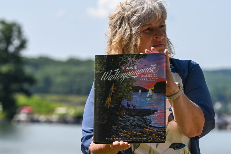 Debbie Gillette, executive director of The Chamber of the Northern Poconos, holds up a copy of the Wallenpaupack Historical Society's book celebrating the centennial of Lake Wallenpaupack.