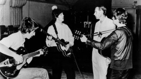 John Lennon, Paul McCartney and George Harrison post in a 1966 publicity photo with their longtime producer and so-called "Fifth Beatle," George Martin. (WikiCommons)