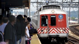 Commuters wait on the platform as a Metro-North train arrives in Bridgeport, Conn.