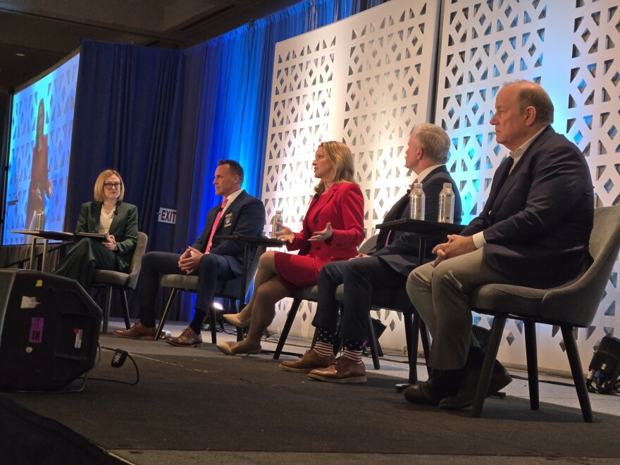 Michigan Public's Zoe Clark moderates a panel of Michigan gubernatorial candidates at a meeting of the Michigan Education Association.