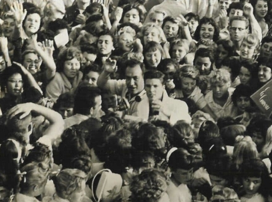 Laboe waves next to actor-musician Ricky Nelson (center, in the white blazer) amid a mob of fans in 1957.