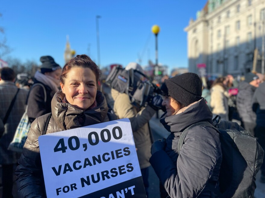 Rosie Woods, a nurse, pickets outside St. Thomas' Hospital in London on Thursday. "You've literally got nurses visiting food banks," she says.