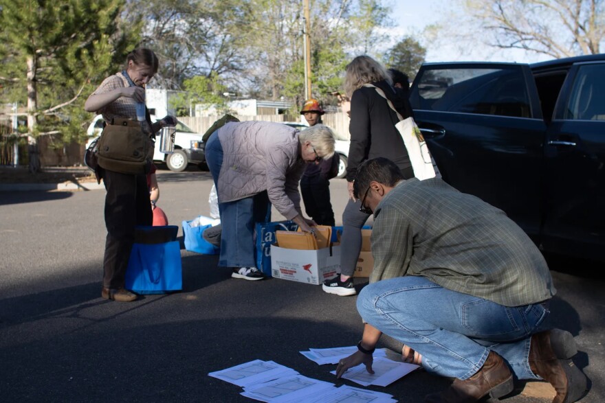 Keep Flagstaff Together volunteers gather to distribute information packets in a Flagstaff neighborhood on April 8, 2026.
