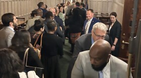 State senators line up to get their paychecks after passing the budget.
