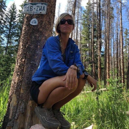 Jessica Mills sits under a tree.