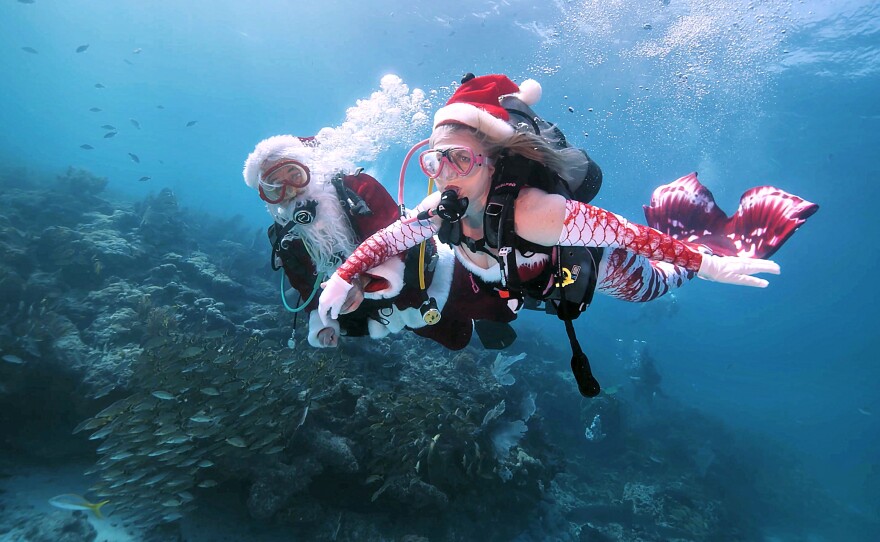 Talk about a Merry merger! Spencer Slate, dressed as Santa Claus, and Donna Whitney as Mrs. Mermaid Claus glide over Pleasure Reef Saturday, Dec. 20, 2025, off Key Largo in the Florida Keys National Marine Sanctuary, proving that even St. Nick needs a tropical getaway before the big night. (Frazier Nivens/Florida Keys News Bureau)