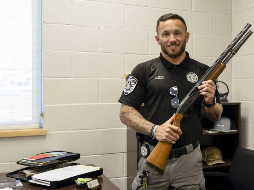 Kingfisher County Sheriff Aaron Pitts stands in his office with the gun initially labeled as missing in an audit by the State Auditor's Office.