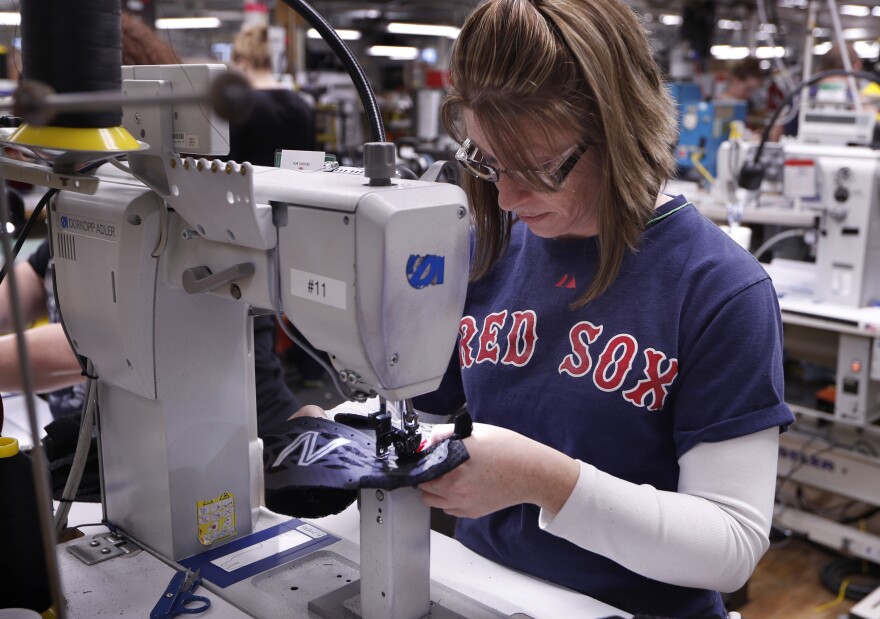 In this Monday, Dec. 17, 2018 photo, Nicole Sanborn stitches the upper section of a pair of athletic shoes designed for the military at a New Balance factory in Norridgewock, Maine.